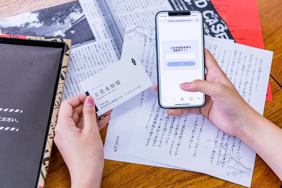 フリーライター立花未知留の名刺と連絡用サイトが表示されたスマートフォン