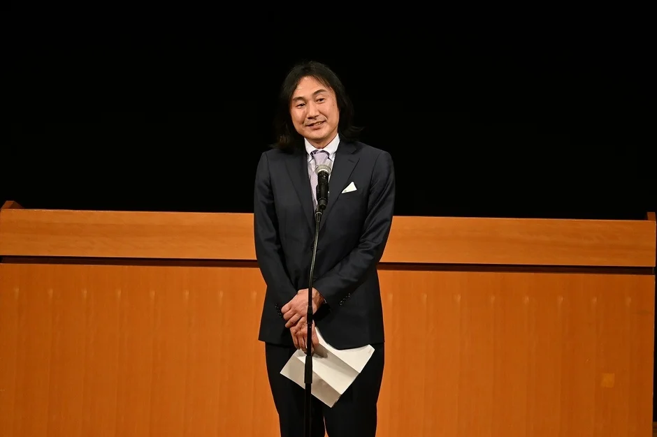 マイクで話す男性