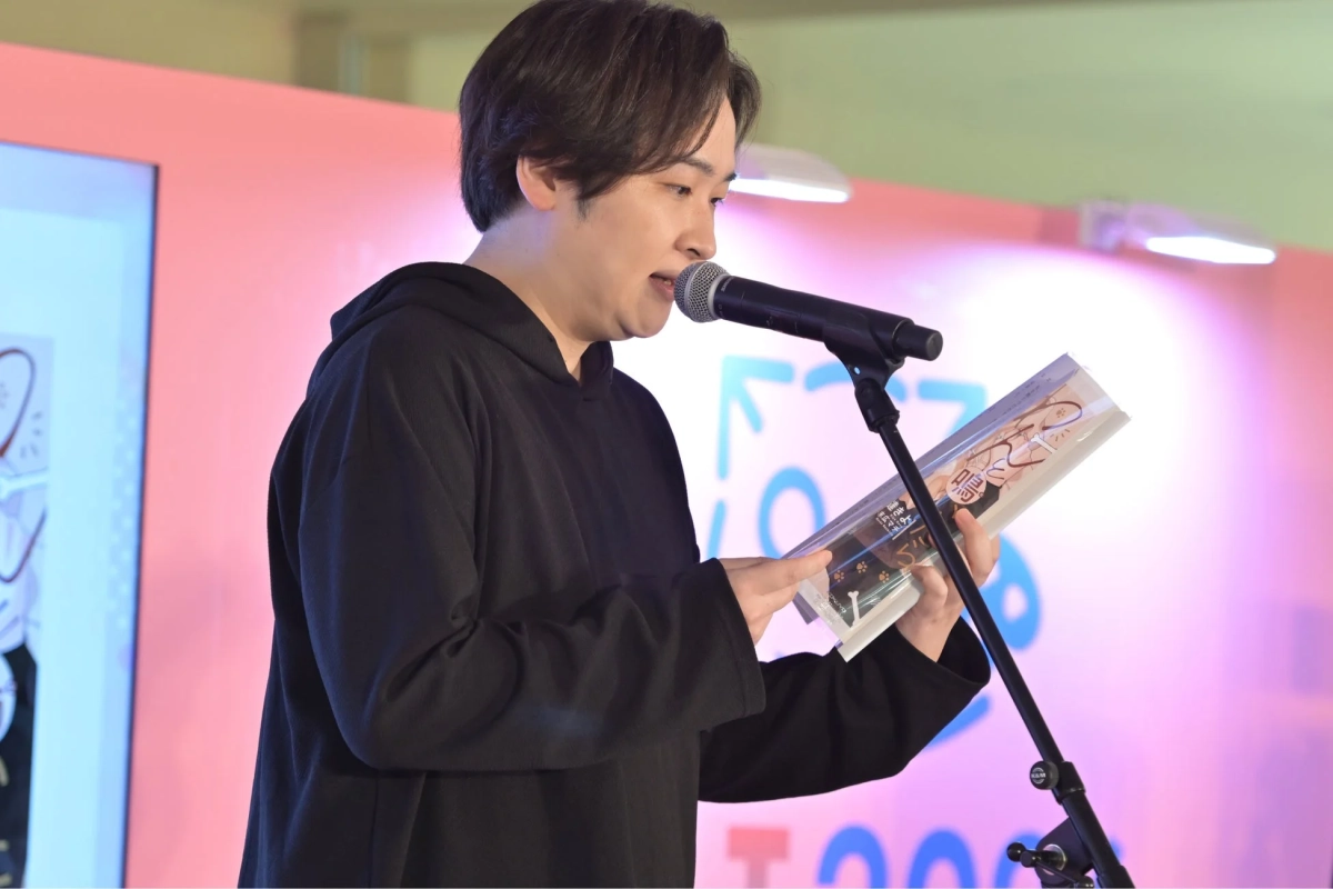 マイクの前で朗読する児玉卓也さん