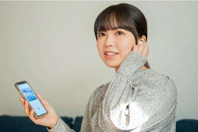 イヤホンで聴く女性の画像
