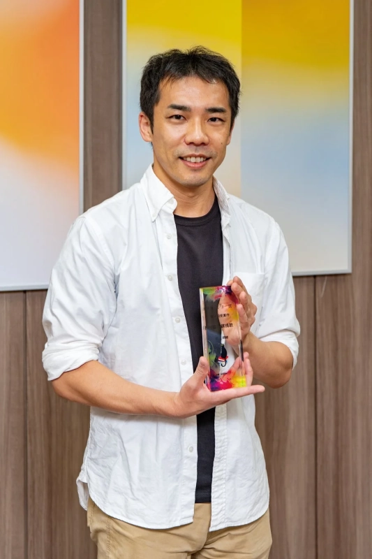 最優秀賞トロフィーを持つ男性